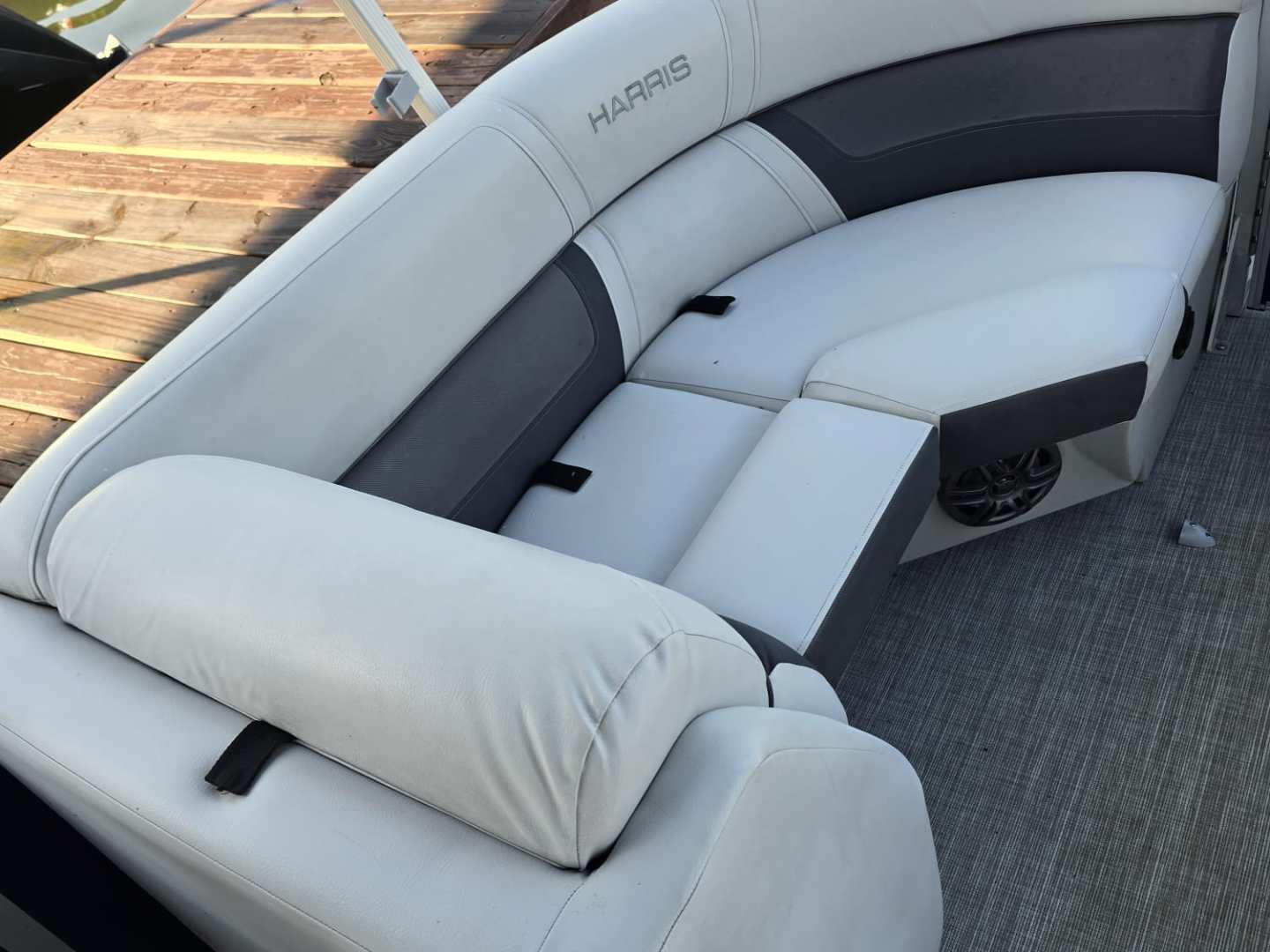 White and gray boat seating with rectangular cushions on a deck.