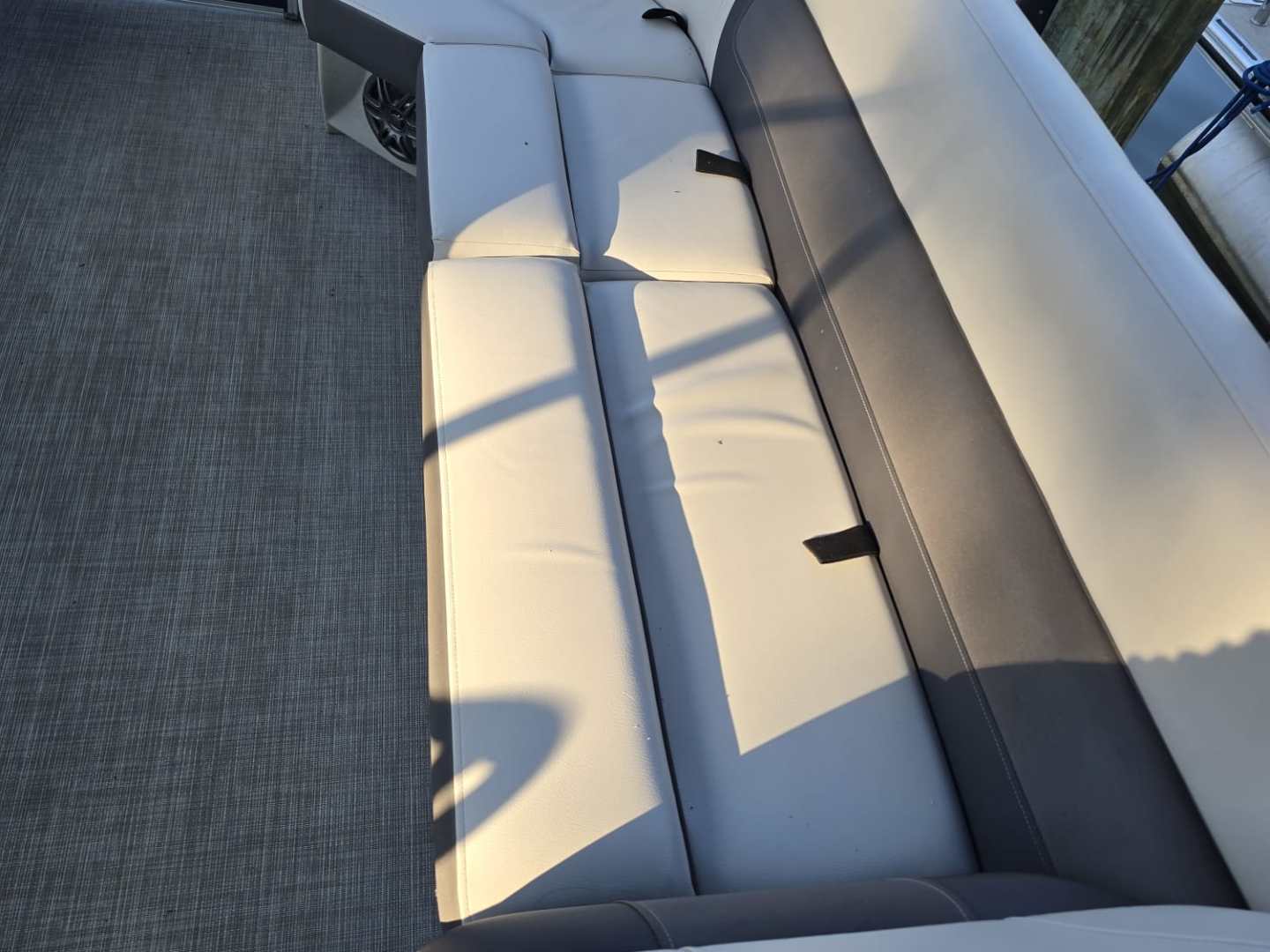 Curved gray and white boat seating with a water view.
