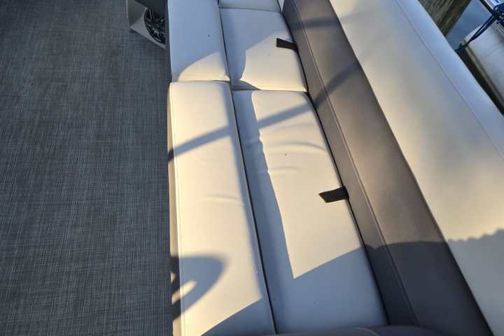 Curved gray and white boat seating with a water view.