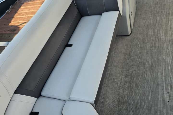 Empty boat seats with gray and white cushions on a docked boat.