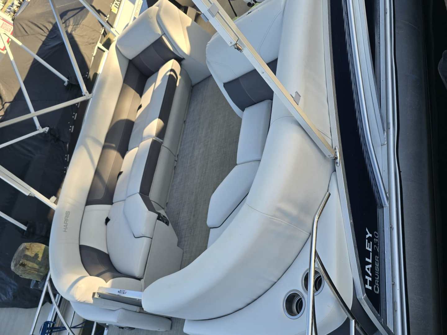 Interior of a pontoon boat with cushioned seating and a canopy.
