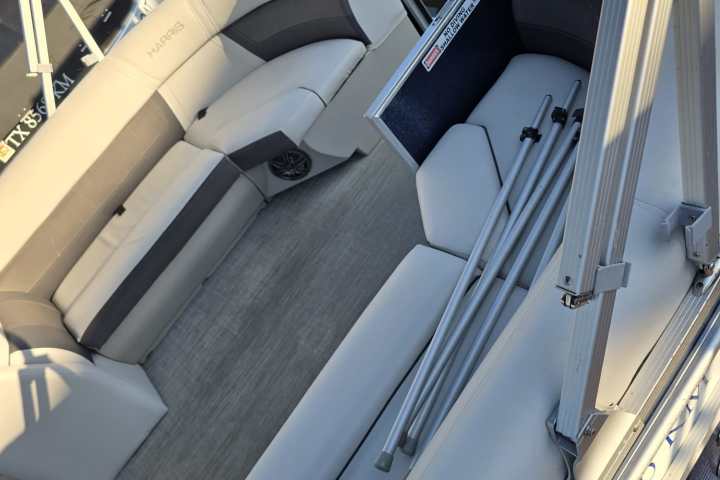 Empty pontoon boat with gray seating and metal railings.