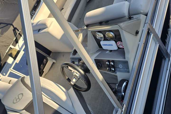 Interior of a boat with modern seats, steering wheel, and control panel.
