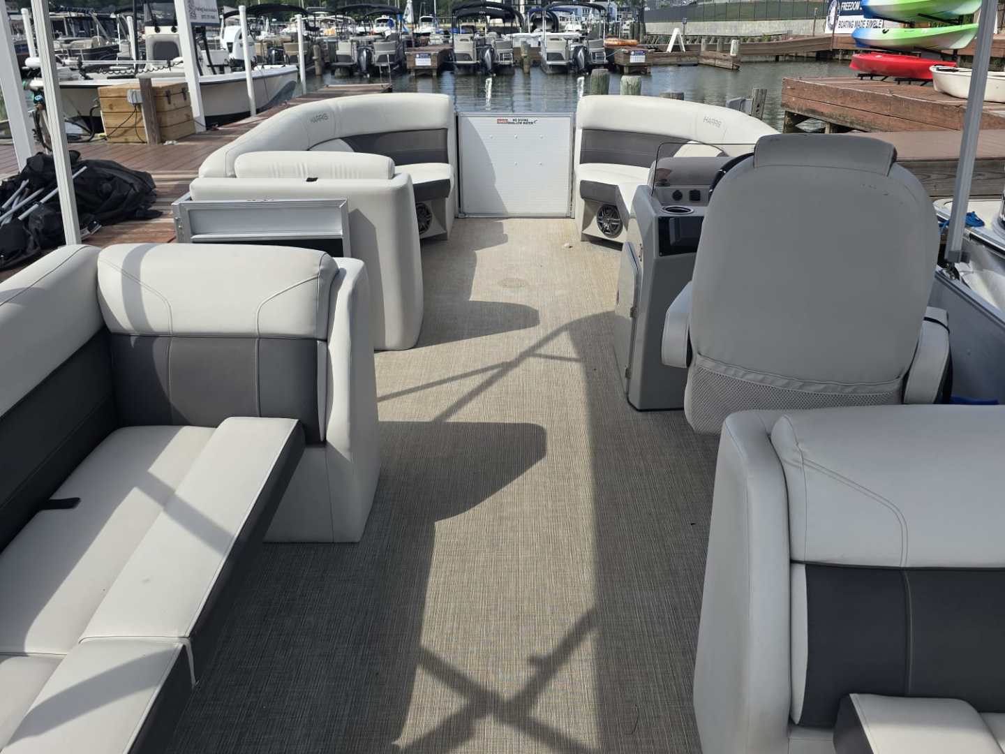 Interior of a boat with seating, docked at a marina.