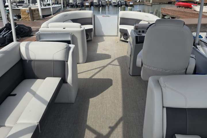 Interior of a boat with seating, docked at a marina.