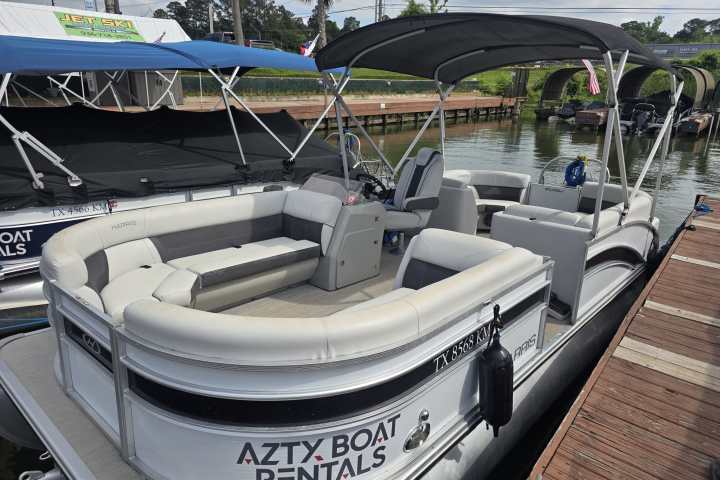Pontoon boat docked, with 'Azty Boat Rentals' displayed on the side.