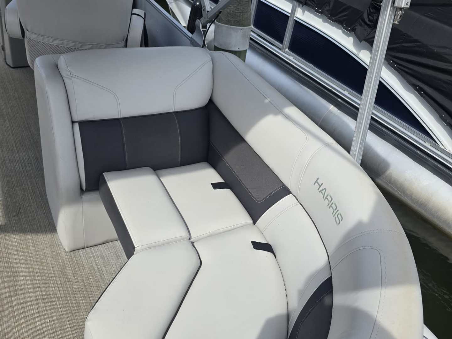 White and gray boat seating on a docked pontoon boat.